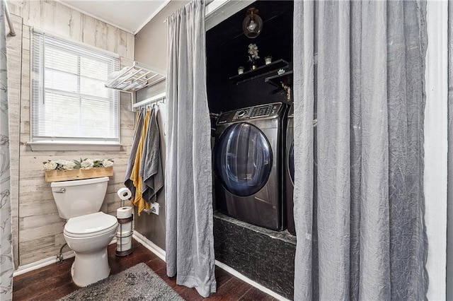 full bathroom featuring bathing tub / shower combination, toilet, washer / clothes dryer, and wood finished floors