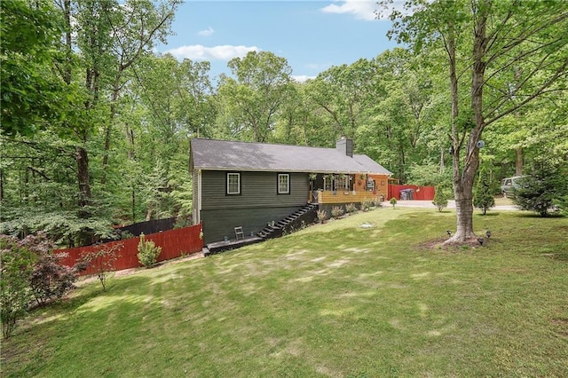 rear view of property with a lawn, fence, a chimney, and stairs