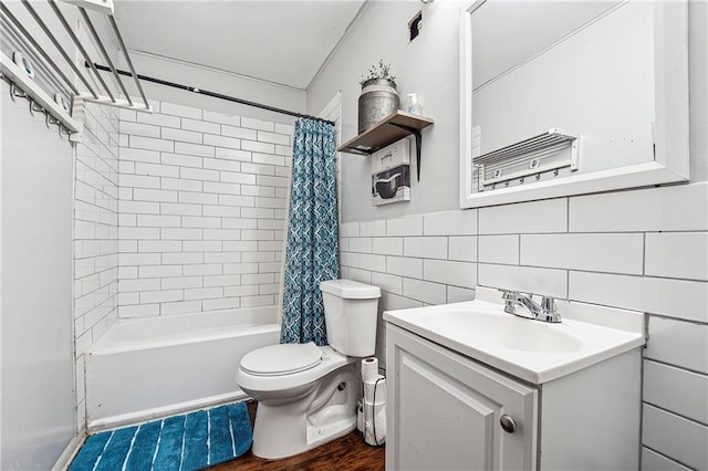 bathroom with tile walls, wood finished floors, shower / tub combo, vanity, and toilet