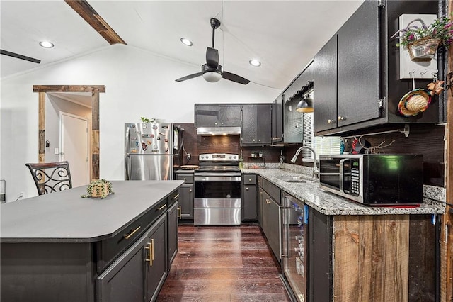 kitchen featuring dark wood-style flooring, wine cooler, under cabinet range hood, a sink, and stainless steel appliances