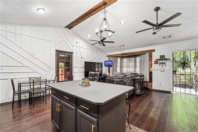 kitchen with lofted ceiling with beams, ceiling fan with notable chandelier, dark wood-style floors, and visible vents