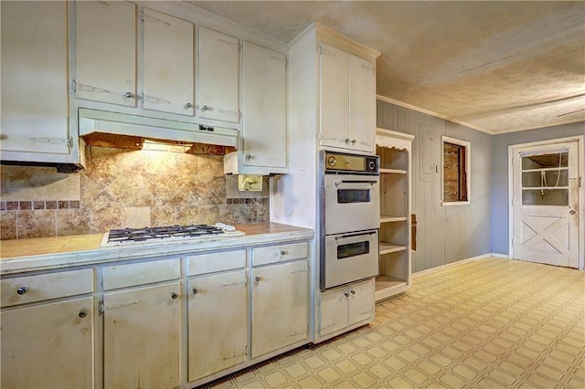 6191 Cumming Hwy, Canton, GA 30115 - kitchen featuring white appliances, ornamental molding, decorative backsplash, light floors, and under cabinet range hood
