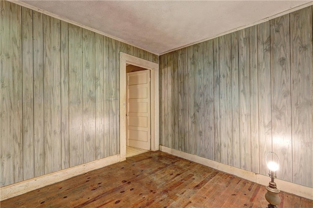 6191 Cumming Hwy, Canton, GA 30115 - spare room featuring hardwood / wood-style flooring, wooden walls, baseboards, a textured ceiling, and crown molding