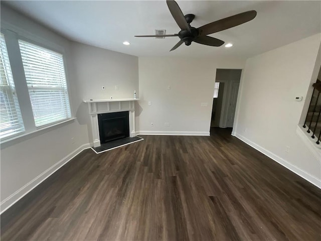 unfurnished living room with dark wood-type flooring and ceiling fan