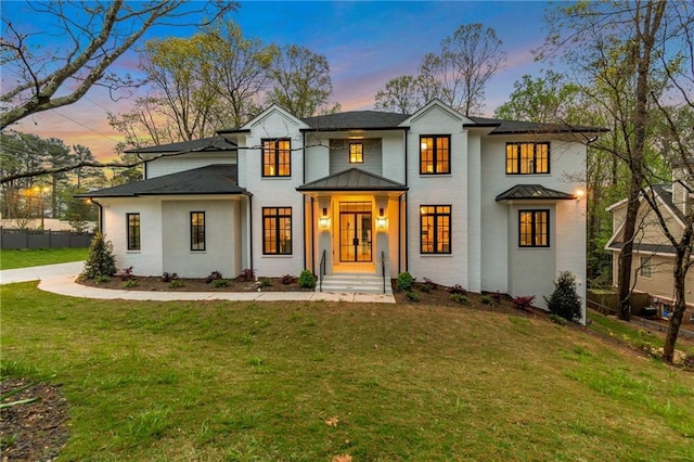 modern inspired farmhouse featuring metal roof, fence, a front yard, and a standing seam roof