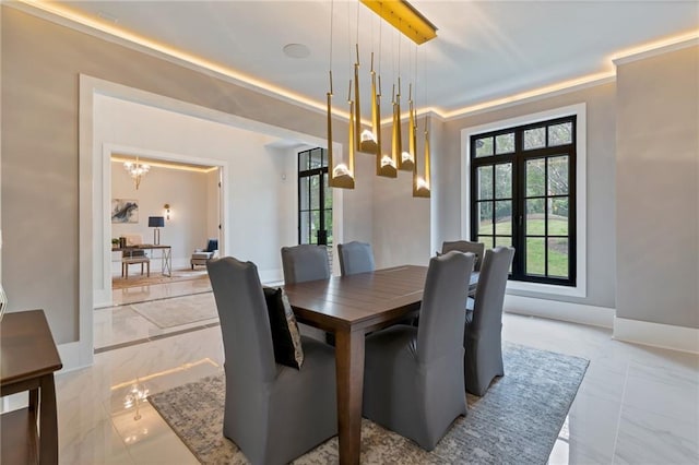 dining area with marble finish floor, baseboards, and an inviting chandelier