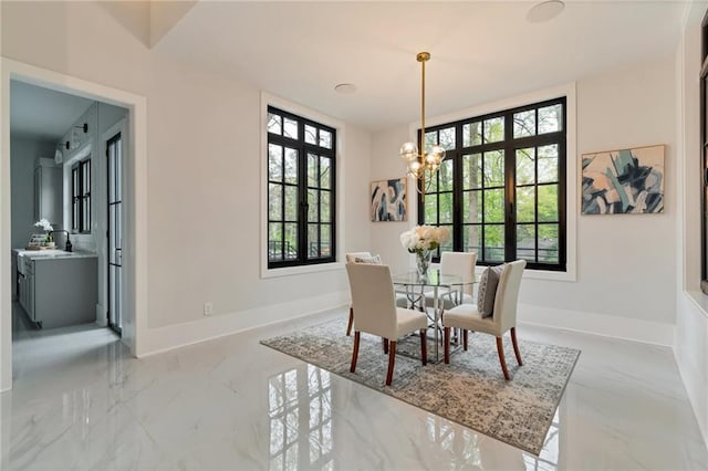 dining space with an inviting chandelier, baseboards, and marble finish floor