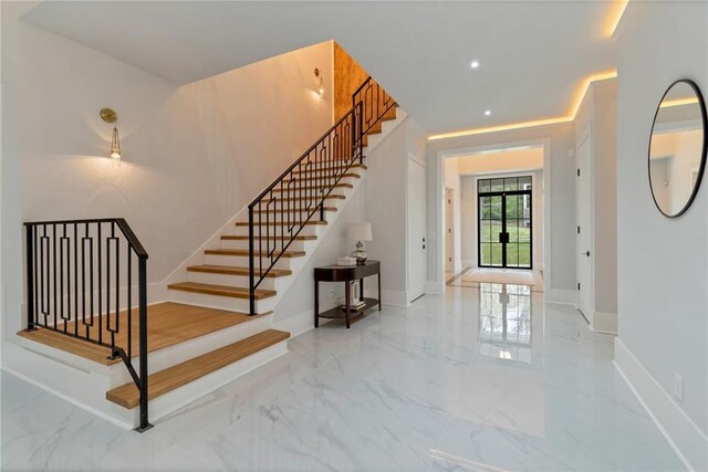 entryway with stairway, baseboards, and marble finish floor