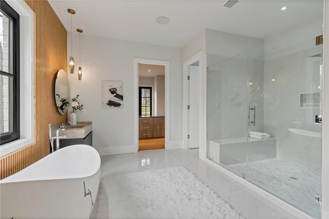 bathroom with marble finish floor, a marble finish shower, baseboards, a freestanding bath, and vanity