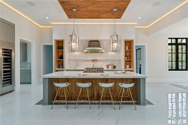 kitchen featuring open shelves, wall chimney range hood, marble finish floor, and a chandelier