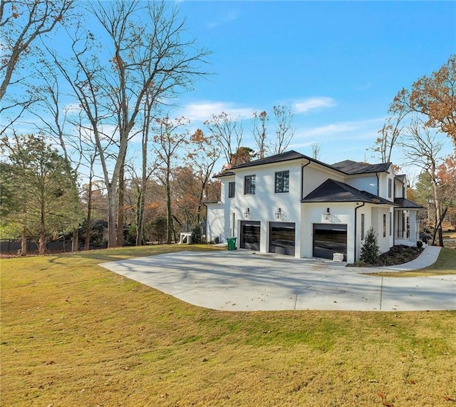 view of side of home with a garage, stucco siding, concrete driveway, and a yard