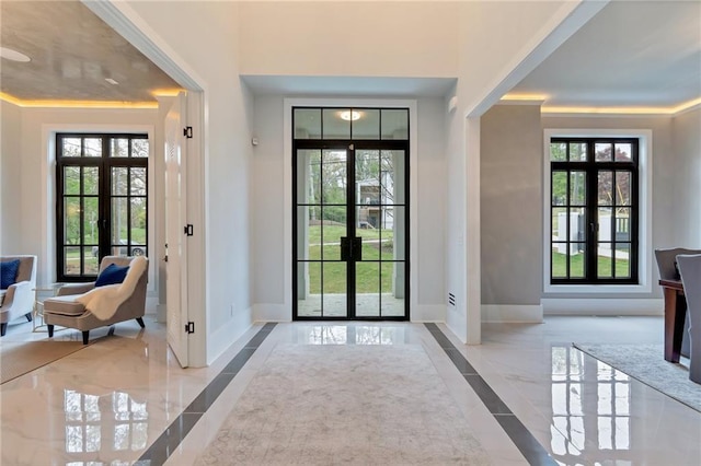 foyer entrance with french doors, baseboards, and marble finish floor