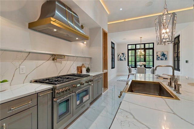 kitchen with range with two ovens, island exhaust hood, an inviting chandelier, marble finish floor, and a sink