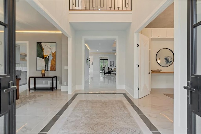 foyer entrance with baseboards and marble finish floor