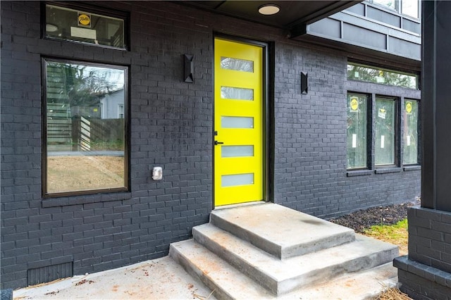 doorway to property featuring brick siding