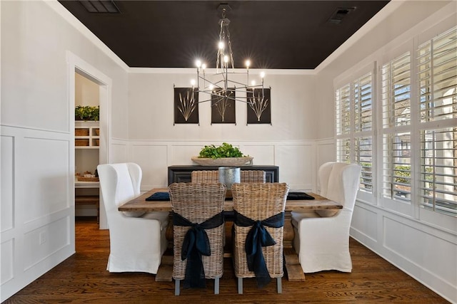 7165 Cordery Rd, Cumming, GA 30040 - dining space with a chandelier, a decorative wall, wood finished floors, crown molding, and a wainscoted wall