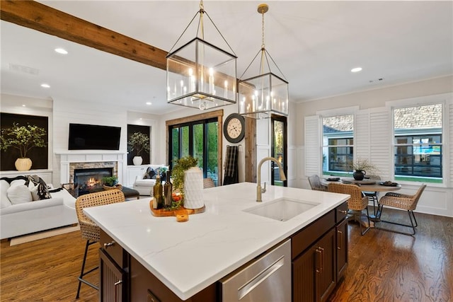 7165 Cordery Rd, Cumming, GA 30040 - kitchen featuring open floor plan, a sink, dishwasher, dark wood-style floors, and a warm lit fireplace