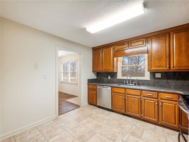 kitchen with stainless steel appliances, sink, backsplash, and a textured ceiling