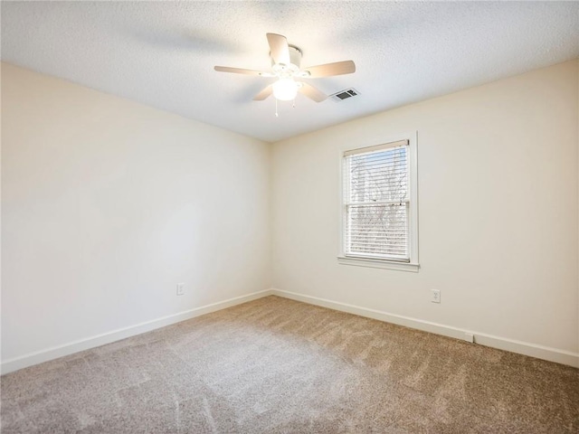 empty room with ceiling fan, carpet, and a textured ceiling