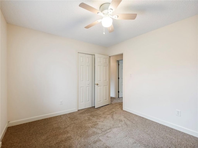 empty room with light carpet, a textured ceiling, and ceiling fan