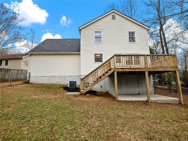 back of house featuring central AC, a lawn, a deck, and a patio area