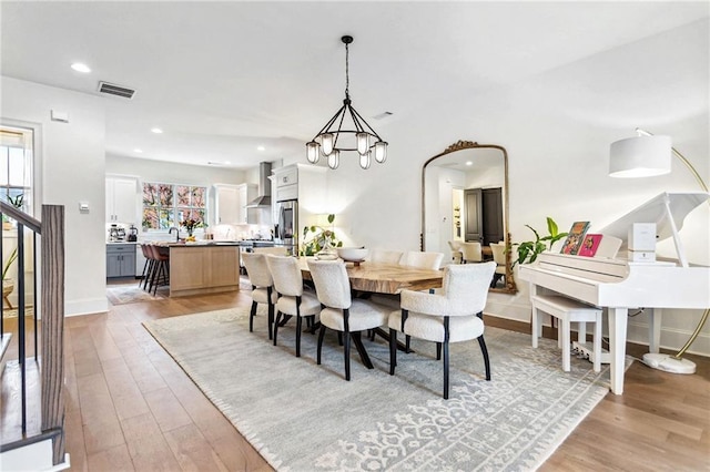 dining space with light wood-type flooring and a chandelier