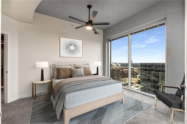 carpeted bedroom with access to exterior, baseboards, visible vents, and a ceiling fan