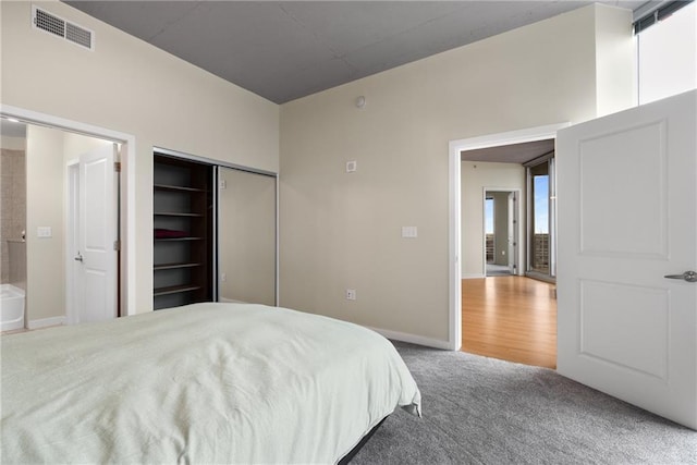 bedroom with carpet floors, baseboards, visible vents, and a closet