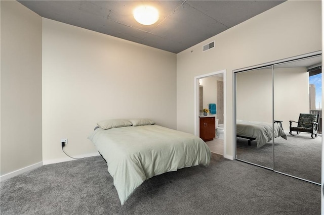 carpeted bedroom featuring a closet, visible vents, and ensuite bath