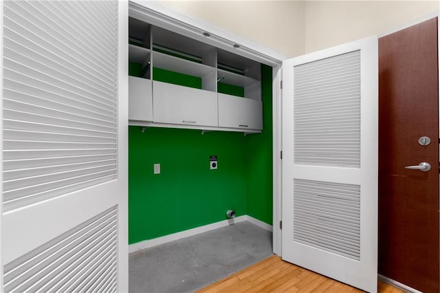 washroom featuring light wood-style floors, cabinet space, and baseboards