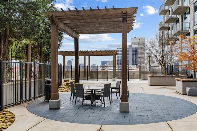 view of patio featuring fence, a city view, and a pergola