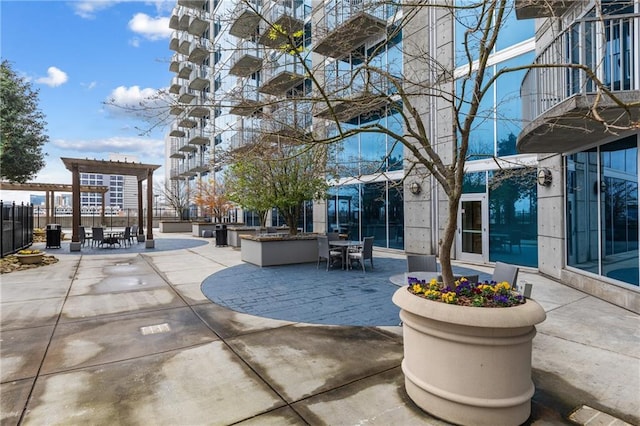 view of community featuring outdoor dining space and a patio