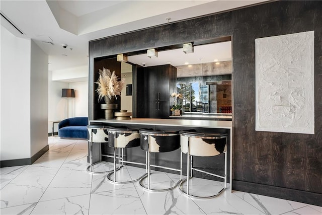 bar with marble finish floor and baseboards