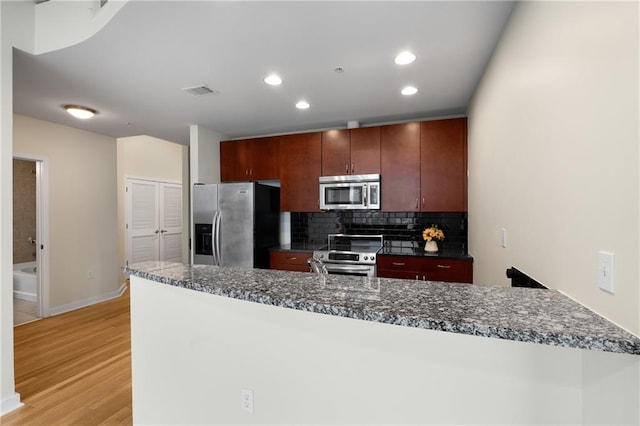 kitchen featuring stainless steel appliances, recessed lighting, visible vents, decorative backsplash, and light wood-type flooring