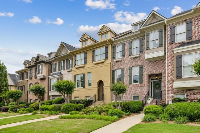 view of property featuring a residential view, a front lawn, and entry steps