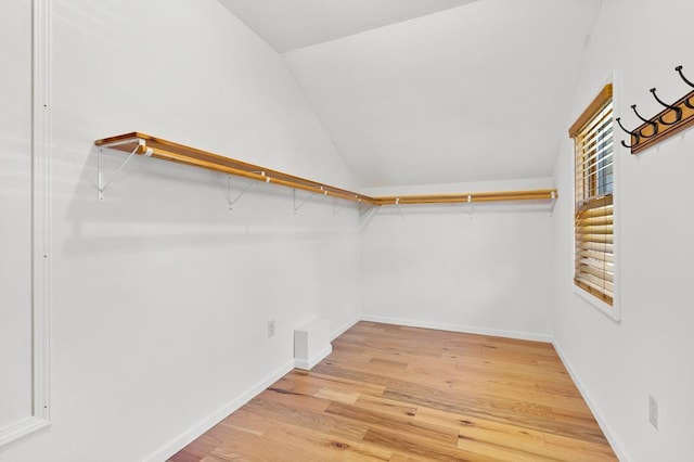 spacious closet featuring vaulted ceiling and light hardwood / wood-style floors