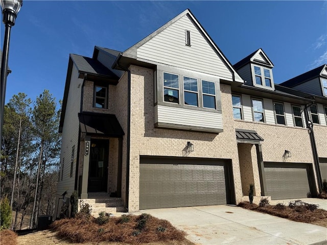 view of front of house featuring central AC unit, concrete driveway, brick siding, and an attached garage