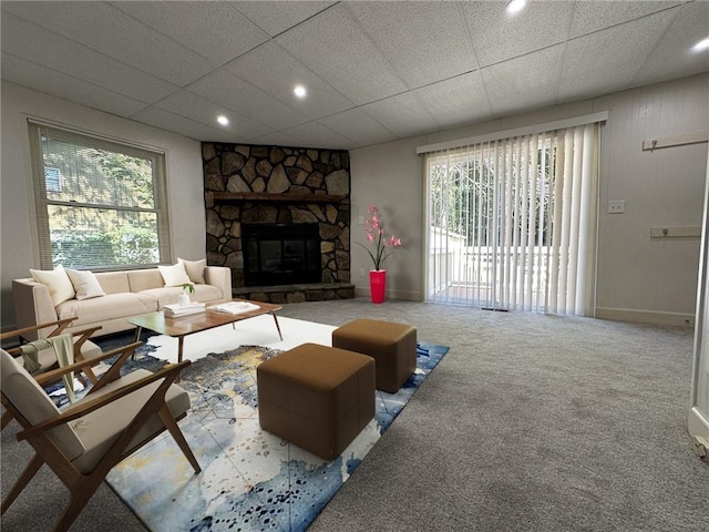 living room featuring a healthy amount of sunlight, a fireplace, and a drop ceiling