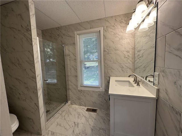 bathroom with visible vents, marble finish floor, a stall shower, and vanity