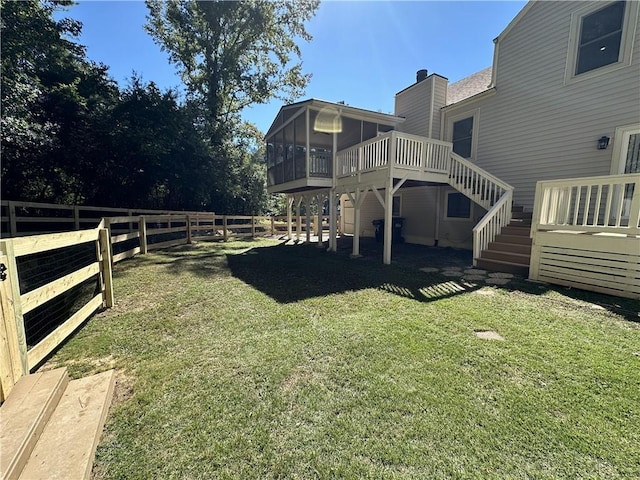 view of yard featuring a sunroom, fence, stairway, and a wooden deck