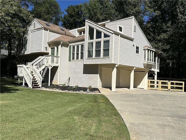 view of front facade with a garage, stairs, a front lawn, and concrete driveway