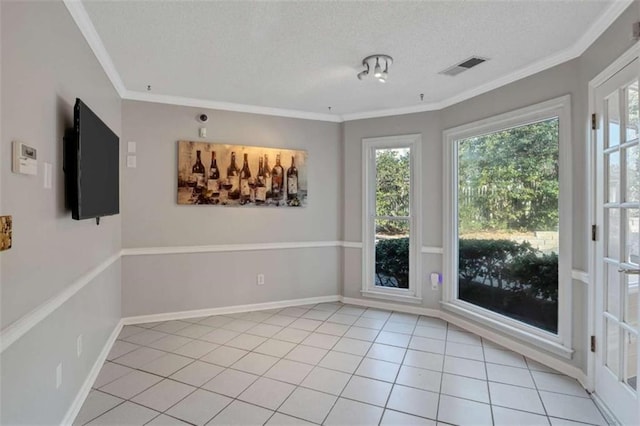 empty room featuring light tile patterned flooring, ornamental molding, and a textured ceiling