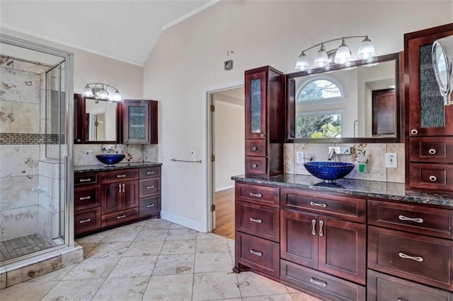 bathroom with lofted ceiling, vanity, backsplash, tile patterned floors, and an enclosed shower