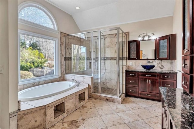 bathroom with lofted ceiling, vanity, and plus walk in shower