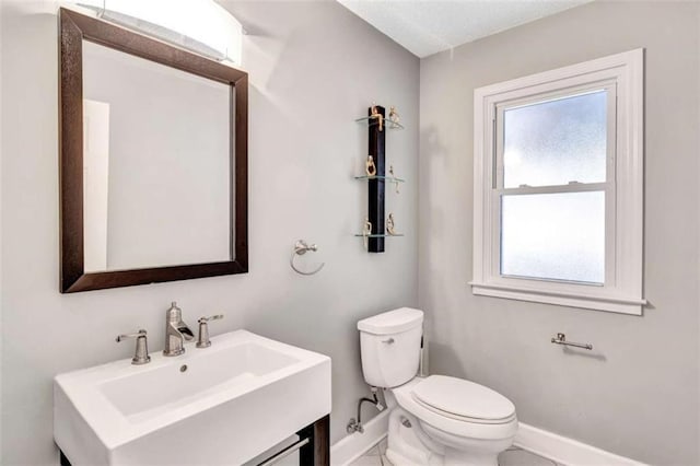 bathroom featuring sink, a wealth of natural light, and toilet