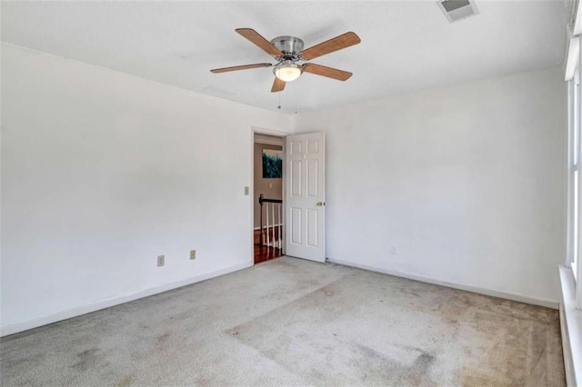 carpeted spare room featuring ceiling fan