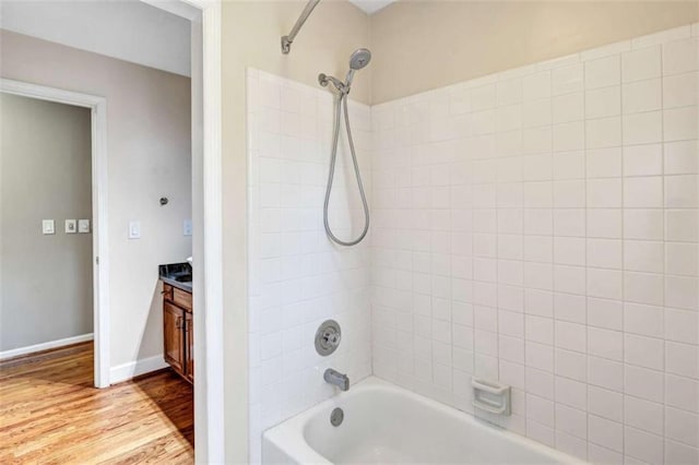 bathroom featuring vanity, wood-type flooring, and tiled shower / bath