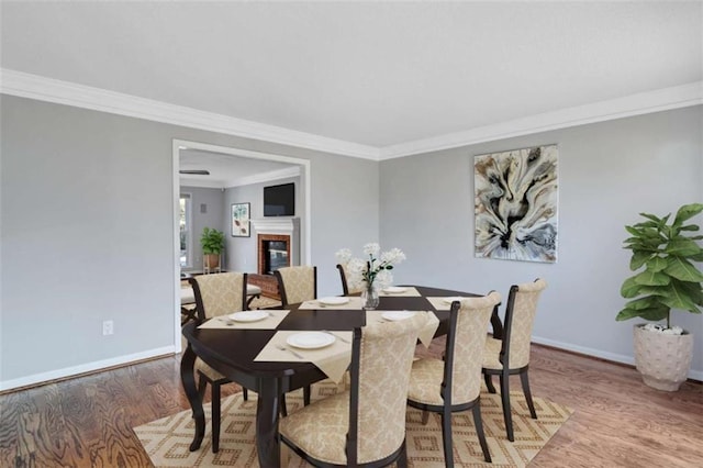 dining space featuring crown molding and wood-type flooring