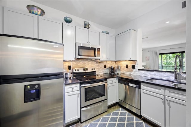 kitchen with appliances with stainless steel finishes, concrete floors, dark countertops, and decorative backsplash