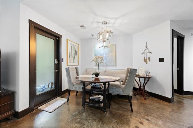 kitchen featuring fridge, concrete flooring, white cabinets, a peninsula, and baseboards